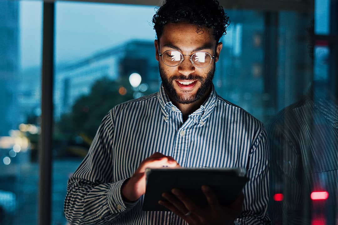 A finance consultant analyzing stock market data from his work tablet in the office.